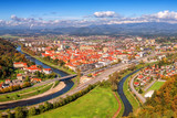 Fototapeta Miasto - City of Celje in Slovenia, Styria, panoramic aerial view from old castle ancient walls. Amazing landscape with town in Lasko valley, river Savinja and blue sky with clouds, outdoor travel background