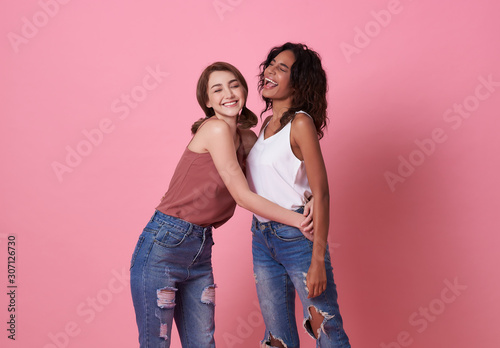 Happy smiling beautiful girl friend hug and wearing casual comfortable shirts isolated on pink background Tableau sur Toile