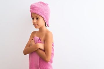 beautiful child girl wearing shower towel after bath standing over isolated white background looking