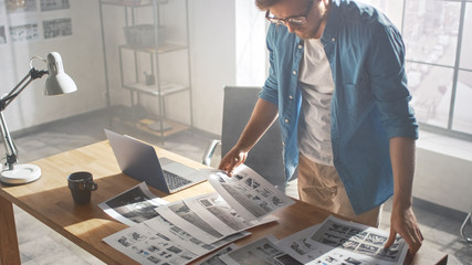 Poster - Creative Designer Works on a Storyboard, Looks at His Sketches and Concepts, Choosing the Best Drawings for His Project. Video Editing, Comics Compilation, Application UI or Game Plot. High Angle