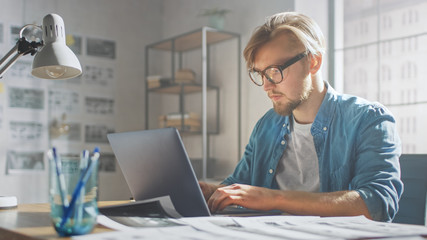 Aufkleber - Creative Developer Works on a Laptop in His Studio. Designing Apps, Games and Doing Video Editing. In the Background Modern Sunny Loft Office with Project Storyboard and Concepts Covering the Wall