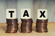 © safriibrahim - Tax Concept with tax word on stacked gold coins