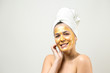 © Mountains Hunter - Beauty portrait of woman in white towel on head with gold nourishing mask on face. Skincare cleansing eco organic cosmetic spa relax concept.