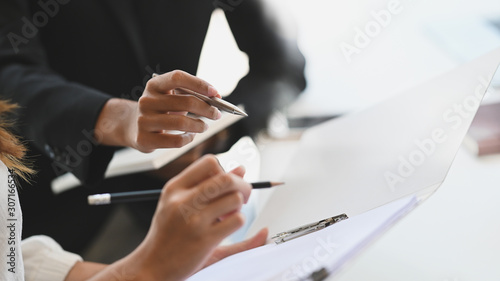 Fotografía Closeup two woman consulting with paperwork document report.
