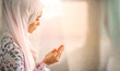 © rachaphak - Young beautiful muslim women open palm, peaceful praying in mosque.