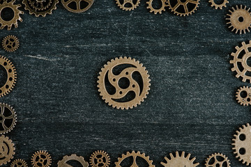 Sticker - top view of vintage metal gears arranged in frame on dark wooden background