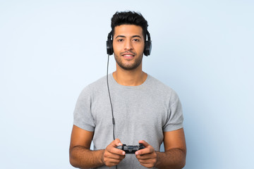 Young handsome man over isolated background playing at videogames