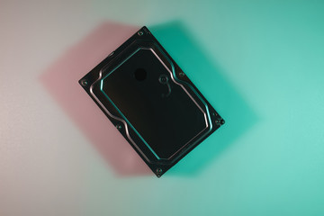 Poster - Beautiful old hard hhd disk in the color light on a table and night background. Top view.