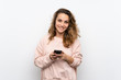 © luismolinero - Young blonde woman sending a message or email with the mobile