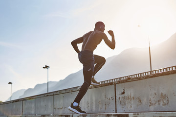 Wall Mural - Athletic man exercising on stadium tribune.