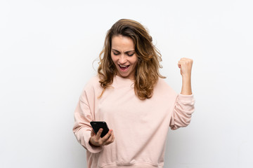 Wall Mural - Young blonde woman using mobile phone