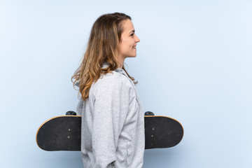 Wall Mural - Young blonde woman with skate in lateral position