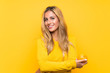 © luismolinero - Young blonde woman holding an orange over yellow background