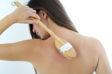 Woman Brushing Back With A Dry Wooden Brush To Prevent And Treatment Body Problem After Shower At Home. Skin Health