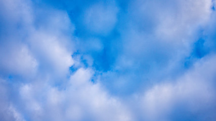light fluffy clouds high in the blue sky.
