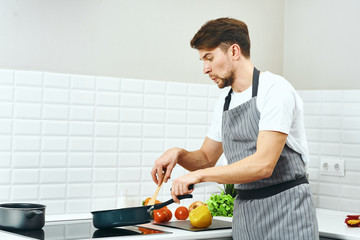 Wall Mural - man cutting vegetables in kitchen