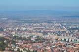 Fototapeta Miasto - Brasov city seen from the Tampa mountain on a fall day. landscape shoot with mountain blurred on the background and the city buildings in front of the screen