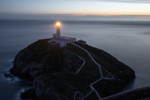 Lighthouse At South Stack In Holyhead, North Wales. South Stack Lighthouse At Sunset Overlooking The Irish Sea Isle Of Anglesey