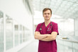 © Kiryl Lis - Smiling male doctor weared in burgundy outfit in white corridors of clinic