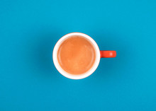 Fresh Brewed Coffee In Ceramic Orange Cup Over Blue Background.
