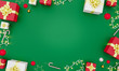 Christmas and New Year decoration flat lay on green background. Holiday greeting card. Christmas na New Year background concept. Gift boxes, candy canes, christmas tree branches and toys. Mockup.