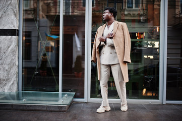 Stylish afro man in beige old school suit and coat. Fashionable young African male in casual jacket on bare torso.