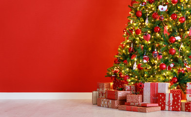 christmas tree on the background of red empty wall.