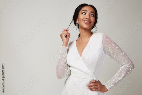 Photographie Beautiful sexy lady fashion pretty woman model pose wear shine white silk shiny dress collection clothes style for party walk skin dark hair glamour accessory cosmetic bride wedding studio