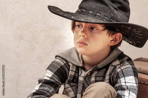 Boy Model In A Cowboy Hat And A Plaid Shirt Of Blond With Long