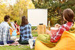 © Pixel-Shot - Friends watching movie in outdoor cinema