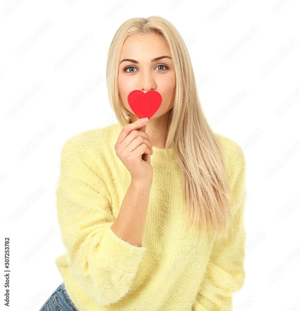 Beautiful young woman with small red heart on white background