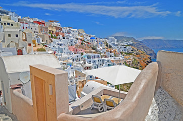 Oia town on Santorini island, Greece. Traditional and famous white houses and churches with blue domes over the Caldera, Aegean sea.