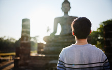 Young Thai Male Tourist Looking At Buddha Statue In Sukhothai Historial Park Thailand