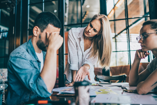 Cuadros en Lienzo Woman team leader asking male coworker to explain mistake in document