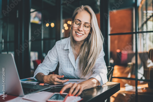 Fotografía Cheerful freelancer checking notifications on smartphone
