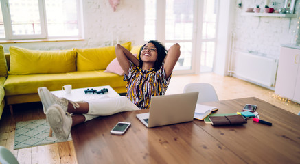 Smiling black student relaxing after working on laptop