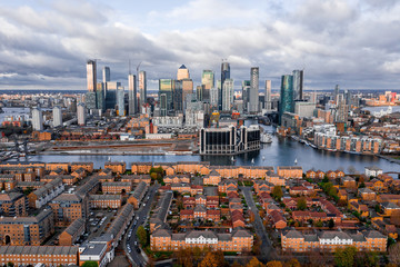 Fototapete - London, England - Aerial Panoramic skyline view of Bank and Canary Wharf, central London's leading financial districts with famous skyscrapers at golden hour sunset during cloudy skies.