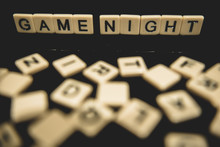 Date Night Spelled Out In Letter Tiles On Black Background With Boardgames In The Background