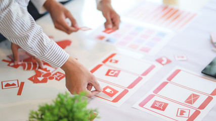 Group of professional UX graphic designer discussing the smartphone template project together in modern office