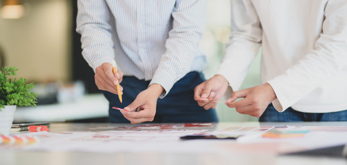 Close-up view of young professional UI web developer team working on smartphone template