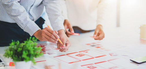 Group of professional UX graphic designer discussing the smartphone template project together in modern office