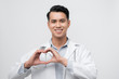 © makistock - Heart sign shown by a male doctor, isolated on white