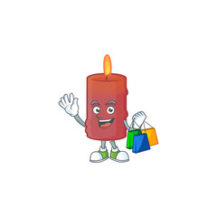 Sticker - Cheerful red candle cartoon character waving and holding Shopping bags