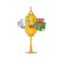 Wall Mural - mascot cartoon of happy lamp hanging with gift box