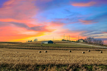 Twilight Sunset Over A Golden Field In The Middle Of Iowa Along Route 80 In The USA.