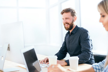 Wall Mural - smiling businessman working on a computer in the office