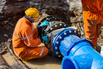 Old big drink water pipes joined with new blue valves and new blue joint members