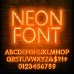 Fototapete - Neon alphabet font. Simple orange neon letters and numbers. Brick wall background. Stock vector typescript for your typography design.