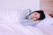 © gballgiggs - Asian woman sleeping on bed and grinding teeth
