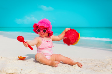 happy cute little girl play with sand and toys on beach